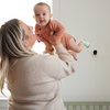 Moeder met baby die de Owlet Dream Sock draagt