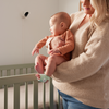Moeder met baby bij de wieg, met de Owlet-camera aan de muur